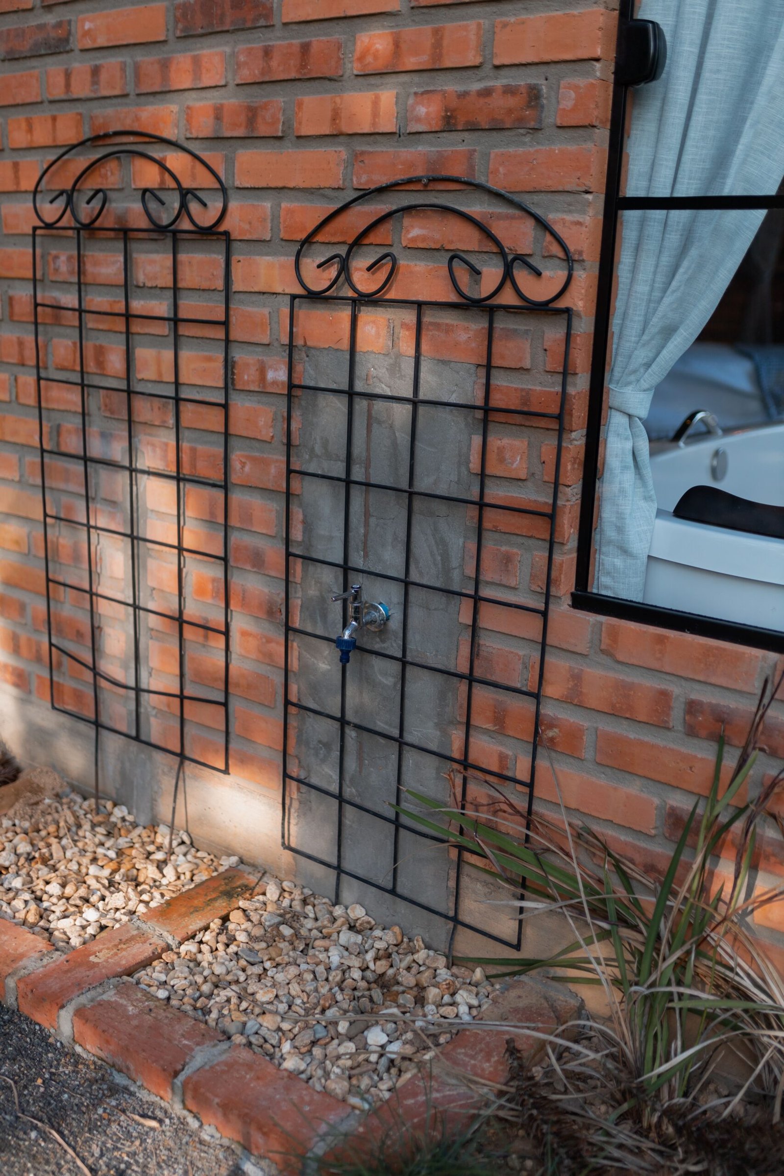 Decorative metal grilles installed on an exterior brick wall